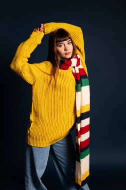 Güzel genç bir kadın, mevsimlik bir fotoğraf çekiminde kendine güvenen, şık bir şekilde poz verir..