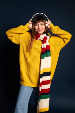 Güzel bir genç kadın müzik dinlerken kendine güvenen bir şekilde poz verir..