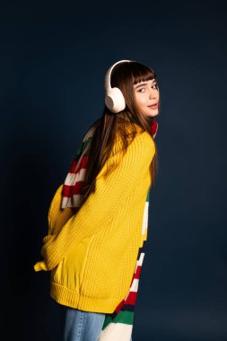 Tarz sahibi genç bir kadın sıcak elbisesiyle neşeli bir şekilde poz verir, mevsimlik havanın tadını çıkarır..