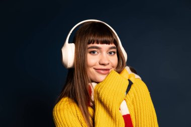 Genç bir kadın sıcak ve şık giysiler içinde gülerek sonbahar atmosferinin özünü yakalıyor..