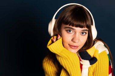 Genç bir kadın müziğin tadını çıkarırken canlı bir kazakla moda anlayışını sergiliyor..