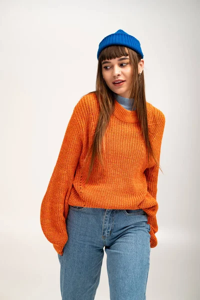 Güzel genç bir kadın şık bir sonbahar elbisesi içinde, mevsimsel tarzı kucaklayarak poz veriyor..