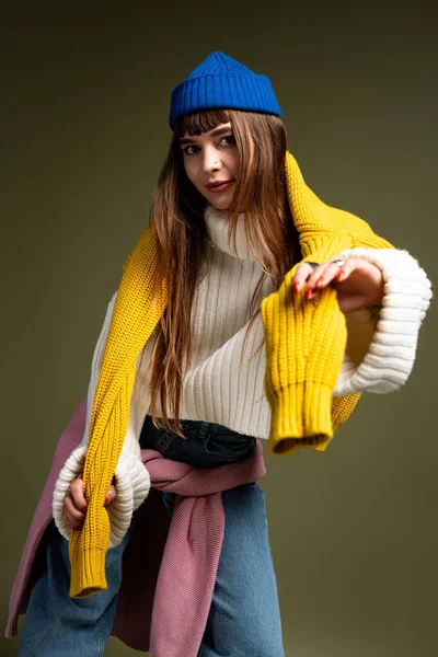 Güzel genç bir kadın şık bir sonbahar elbisesi içinde canlı renklerle poz verir..