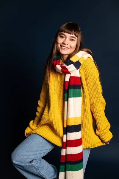 Güzel genç bir kadın, güz mevsiminin soğuğunu kucaklayarak, sıcak bir şekilde poz verir..