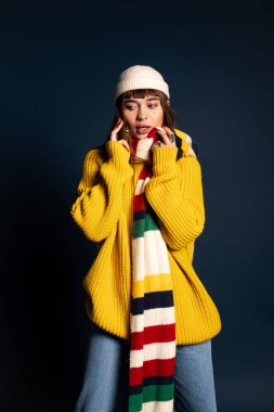 Hareketli genç kadın canlı kış giysileri içinde poz veriyor. Isınma ve kendine güven saçıyor..