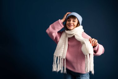 Güzel, genç bir kadın, güz mevsiminin sıcacık havasını kutlamak için, sıcak giysiler içinde poz verir..