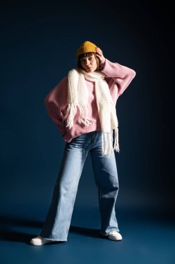 Rahat moda içinde genç bir kadın aktif olarak kendine güvenerek poz veriyor, canlı tarzını sergiliyor..