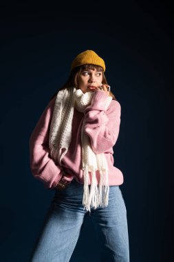 Genç kadın, güz havasını kucaklayarak, sıcak ve şık giysilerle poz veriyor..