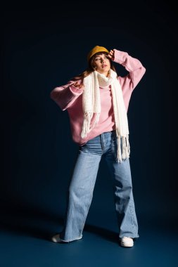 Güzel genç bir kadın, canlı tarzını, sonbahar mevsimini kutlamak için sıcak katmanlar halinde sergiliyor..