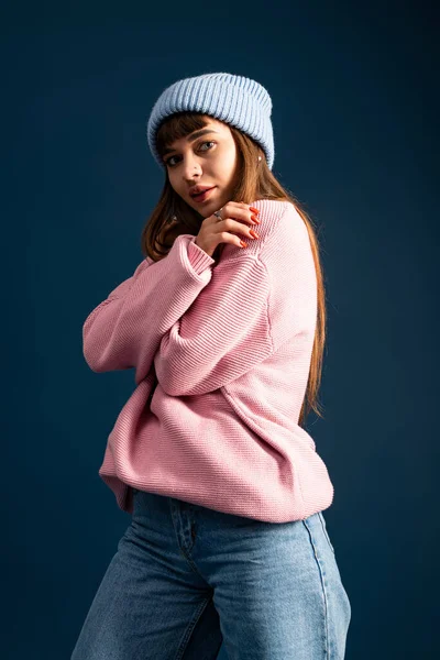 Genç bir kadın moda ve konforu harmanlayan şık bir kış elbisesi içinde poz verir..