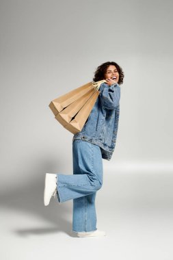 Beautiful young woman smiles brightly while enjoying her shopping day with stylish bags in hand.