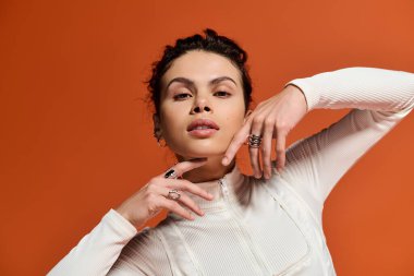 Confident woman showcases her unique jewelry and stylish outfit in a stunning setting.