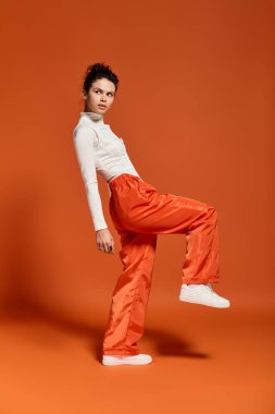 A beautiful young woman confidently poses in trendy attire, highlighting her unique fashion sense.