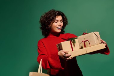 Stylish woman embraces a moment of delight while holding beautifully wrapped gifts.