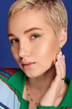 Şık bir genç kadın moda görünümünü koyu yeşil göz makyajı ve şık aksesuarlarıyla sergiliyor..