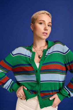 Genç bir kadın kendine güvenerek tarzını açık yeşil çizgili bir bluzla sergiliyor..