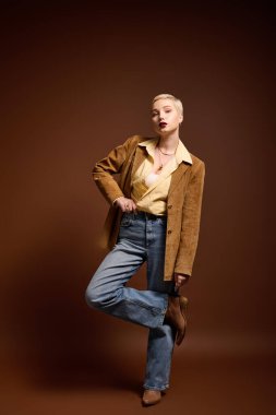 Modaya uygun genç bir kadın şık bir kıyafetle, ışıl ışıl ve dengeli duruyor..