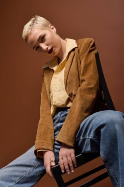 Tarz sahibi genç bir kadın, özgüvenli bir şekilde yaratıcı bir stüdyo ortamında poz veriyor..