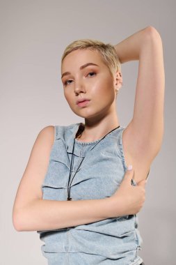 Güzel genç bir kadın şık bir bakışla, zarif bir pozla moda anlayışını sergiliyor..