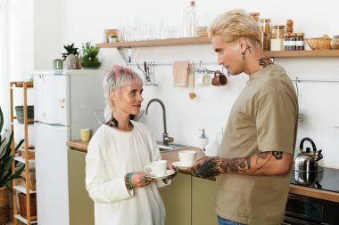 Genç bir çift olarak aşk çiçekleri mutfaklarında birlikte kahvenin tadını çıkarırlar..