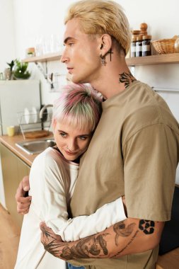 Sevgi dolu bir çift, parlak mutfaklarında samimi bir şekilde kucaklaşır, mutlu ve bağlı hissederler..