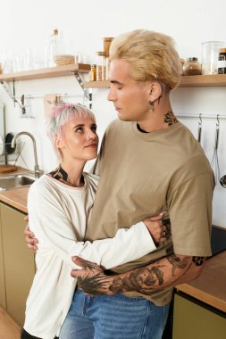 Şık mutfaklarında sevgi dolu bir çift, şefkatli bakışlarını paylaşıyor..