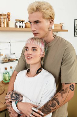 Çift şık bir mutfakta sarılıp derin bağlarını ve neşelerini sergiliyor..