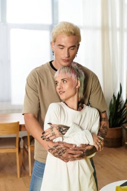 Sıcak bir ışık ve rahatlatıcı bir atmosferle çevrili genç bir çift birbirlerini kucaklıyor..