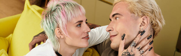A young couple gazes into each others eyes, radiating joy and affection in a stylish room.
