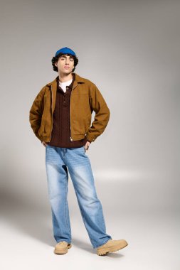 Tarafsız bir ortamda modaya uygun kıyafetler giyen genç bir adam..