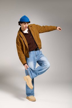 Genç yakışıklı adam, modaya uygun bir kıyafetle benzersiz bir tarz sergiliyor. Kendine güveni ve yeteneği var..