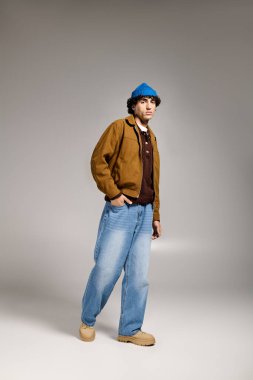 Genç ve çekici erkek modaya uygun kıyafetler, rahat duruş ve kendine güvenle duruyor.