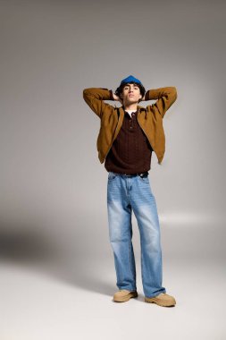 Çekici genç adam şık bir stüdyo ortamında poz verirken şık kıyafetler sergiliyor..