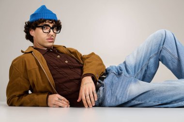 Şık bir genç adam rahat bir ortamda rahatlar, şık görünüşünü ön plana çıkarır..