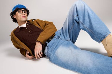 Kendine güvenen genç adam yaratıcı bir mekanda öylesine uzanırken enerjik bir moda sergiliyor..