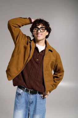 Kendine güvenen genç bir adam modern tarzın altını çizerek modaya uygun bir şekilde poz verir..