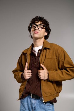 Genç ve yakışıklı bir adam modaya uygun poz veriyor. Eşsiz tarzını ve çekiciliğini ön plana çıkarıyor..