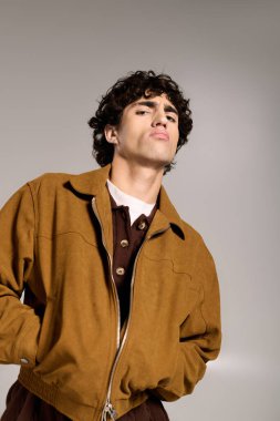 Genç, yakışıklı bir adam, kendine güvenerek kendine has bir havası olan şık bir elbiseyle poz verir..