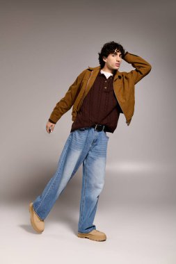 Kendine güvenen genç adam şık bir iç mekanda şık bir kıyafetle dikkatleri üzerine çekiyor.