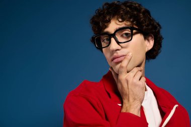 Moda kıyafetli genç adam düşünceli bir poz verirken moda anlayışını sergiliyor..