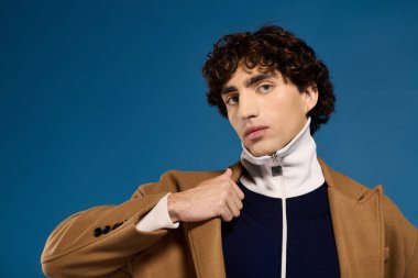 Yakışıklı bir genç adam kendine güvenerek şık giyiniyor, ışık saçıyor ve çekicilik saçıyor..