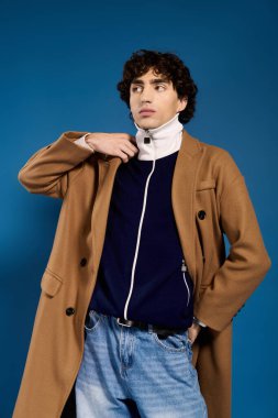 Şık genç adam kendine güvenerek poz veriyor, benzersiz ve modern kıyafetlerini sergiliyor..