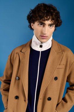 İleri moda genç adam kendine güvenerek poz veriyor, şık kıyafetini ve son moda yeteneğini vurguluyor..