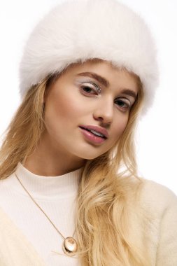 Sarışın genç bir kadın arka planda kış modası ve çarpıcı makyaj modelliği yapıyor..