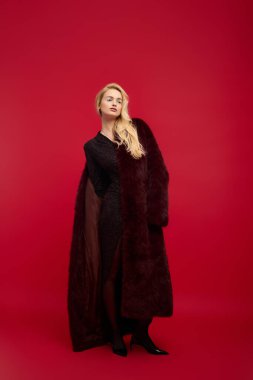 Kırmızı kürklü genç bir kadın, kış tarzı ve zarafetini sergiliyor..