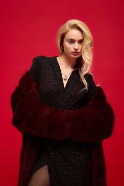 Güzel sarışın bir kadın şık kırmızı bir kürk manken, kış boyunca zarafet saçıyor..