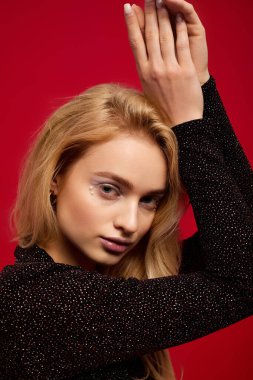 Sarışın, şık bir kadın, siyah bir elbise içinde, tatil sezonunu kutluyor..