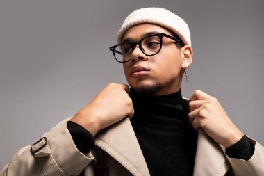 Yakışıklı genç adam zarif poz veriyor, modaya uygun kıyafetlerini sergiliyor..