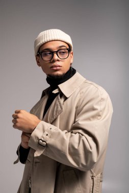 Genç adam kendine güveni tam bir şekilde şık bir şekilde poz veriyor. Cazibesini ve tarzını hiç zorlanmadan sergiliyor..