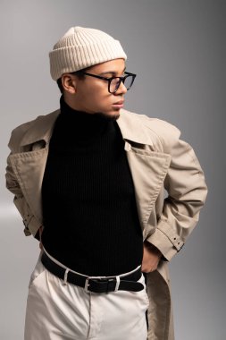 Şık giyinmiş yakışıklı genç adam, çağdaş tasarım alanında güven içinde poz veriyor..